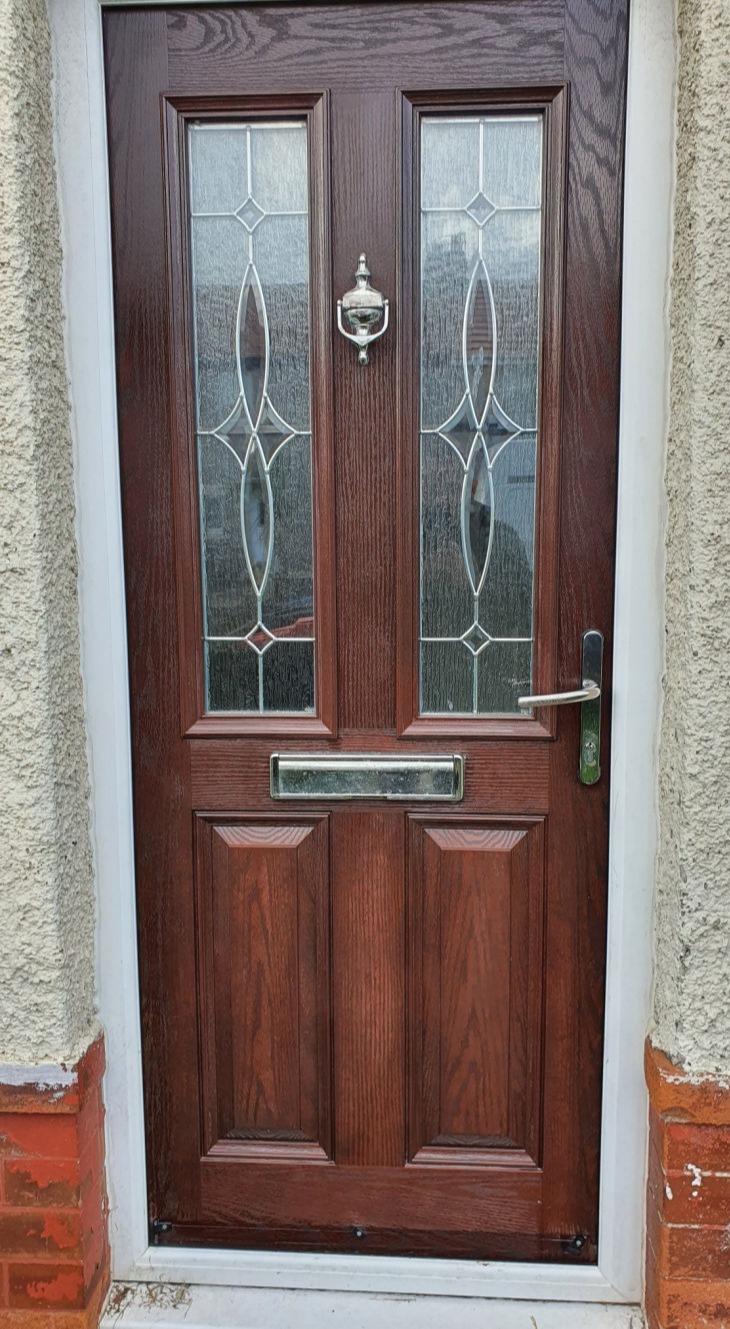 image shows a shining rosewood coloured composite door full restored to its' former glory