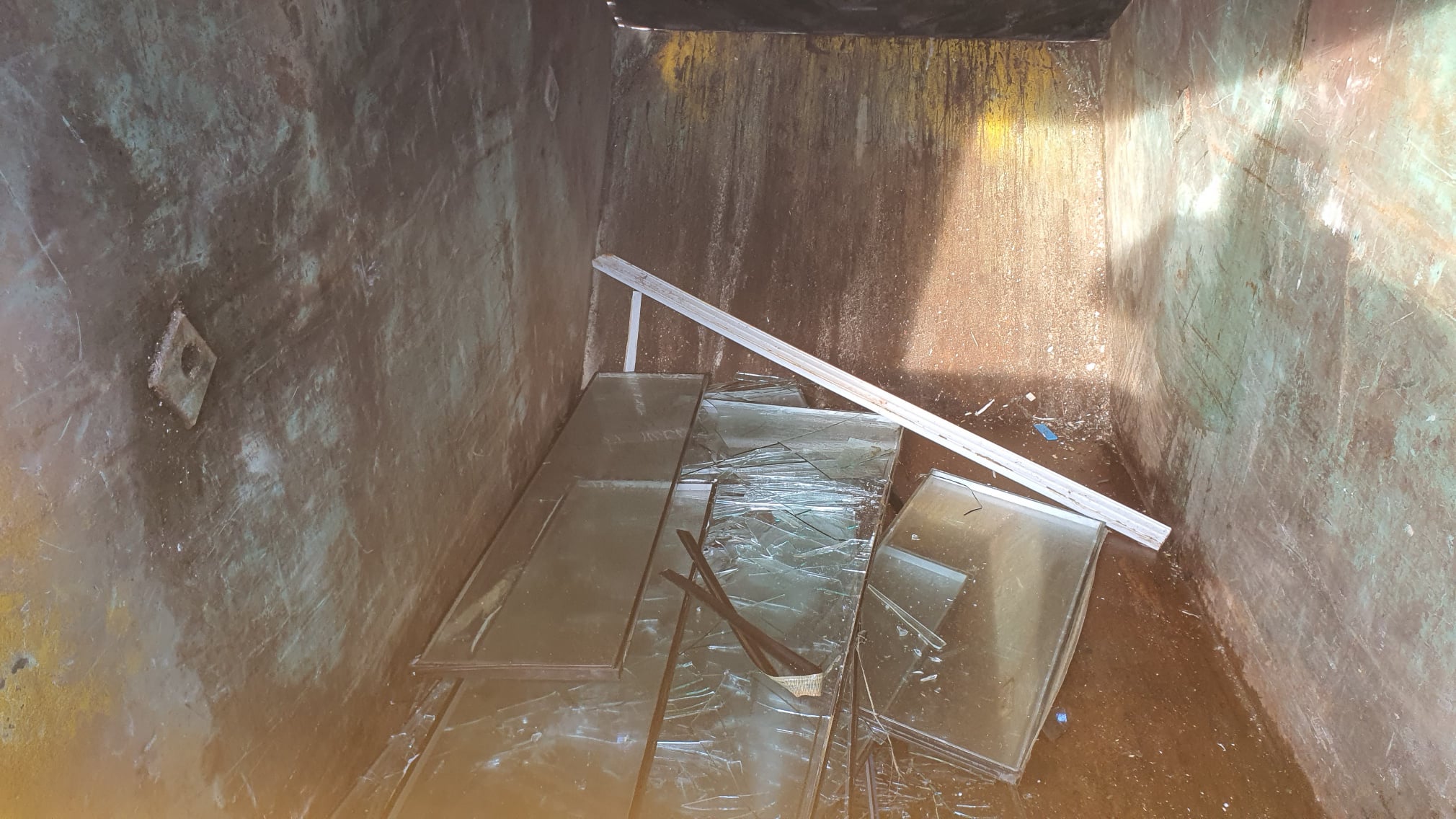 Waste double glazing placed in skip for landfill